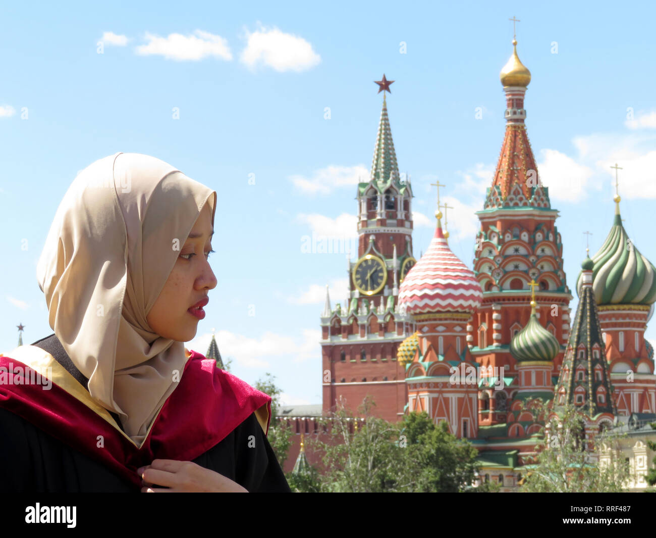 Muslimische Mädchen in der Hijab auf dem Hintergrund der Moskauer Kreml und der Basilius-Kathedrale. Islam in Russland, Bildung für internationale Studierende Stockfoto