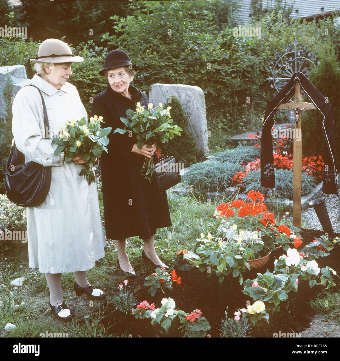 HEIDI UND ERNI/2. Das Testament des Georg Käslinger/Käslinger Sowohl Heidi (HEIDI KABEL) als auch Erni Käslinger (ERNI SINGERL) bringen ihrem verstorbenen Ehemann 27.09.05 Rosen, Käslingers Lieblingsblumen. Beide haben erfahren, dass sie gleichberechtigt erben sollen... / 36301-0/-55325, 02 DFAHeidi1/Überschrift: HEIDI UND ERNI/D 1989-1990 Stockfoto