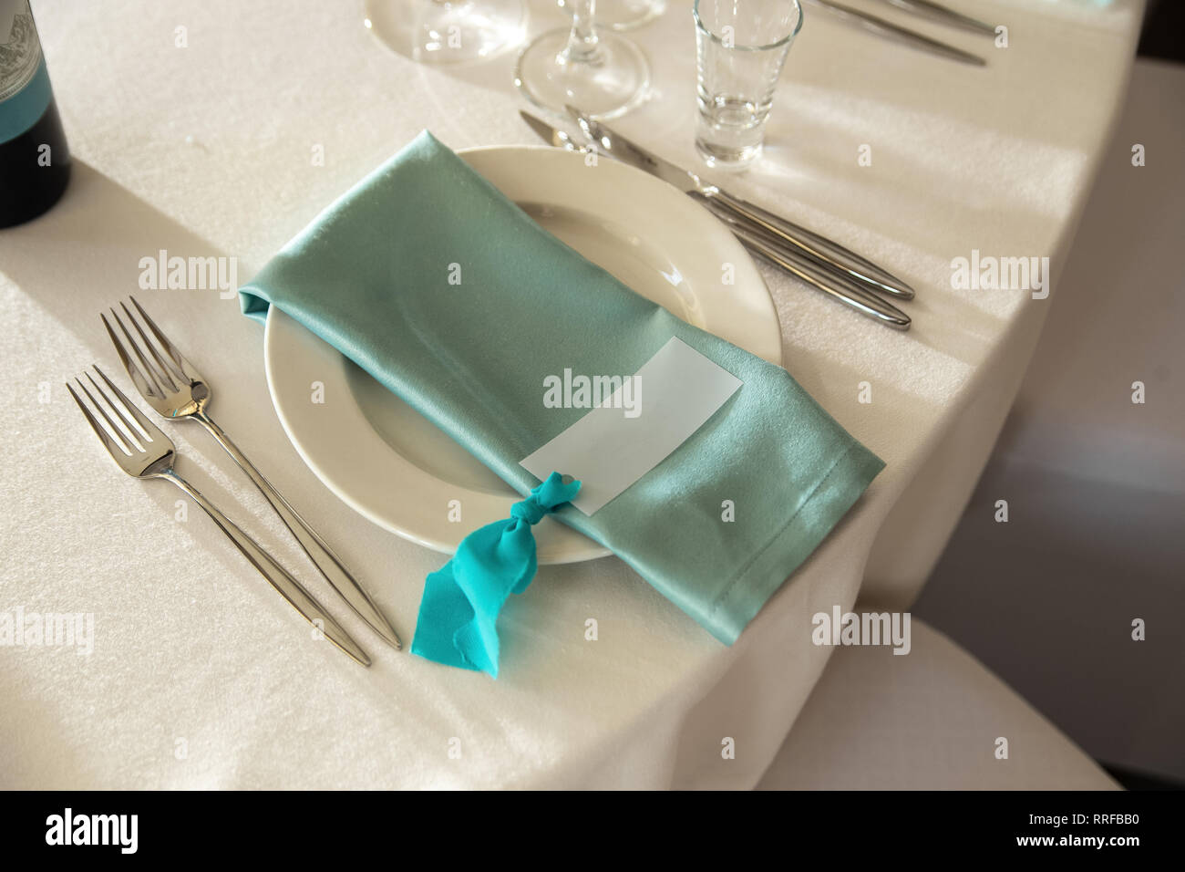 Gästekarte und Aquamarin Serviette mit Liegen auf dem Teller. Stockfoto