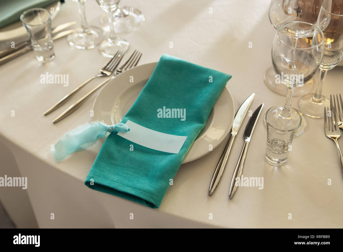 Gästekarte und Aquamarin Serviette mit Liegen auf dem Teller. Stockfoto