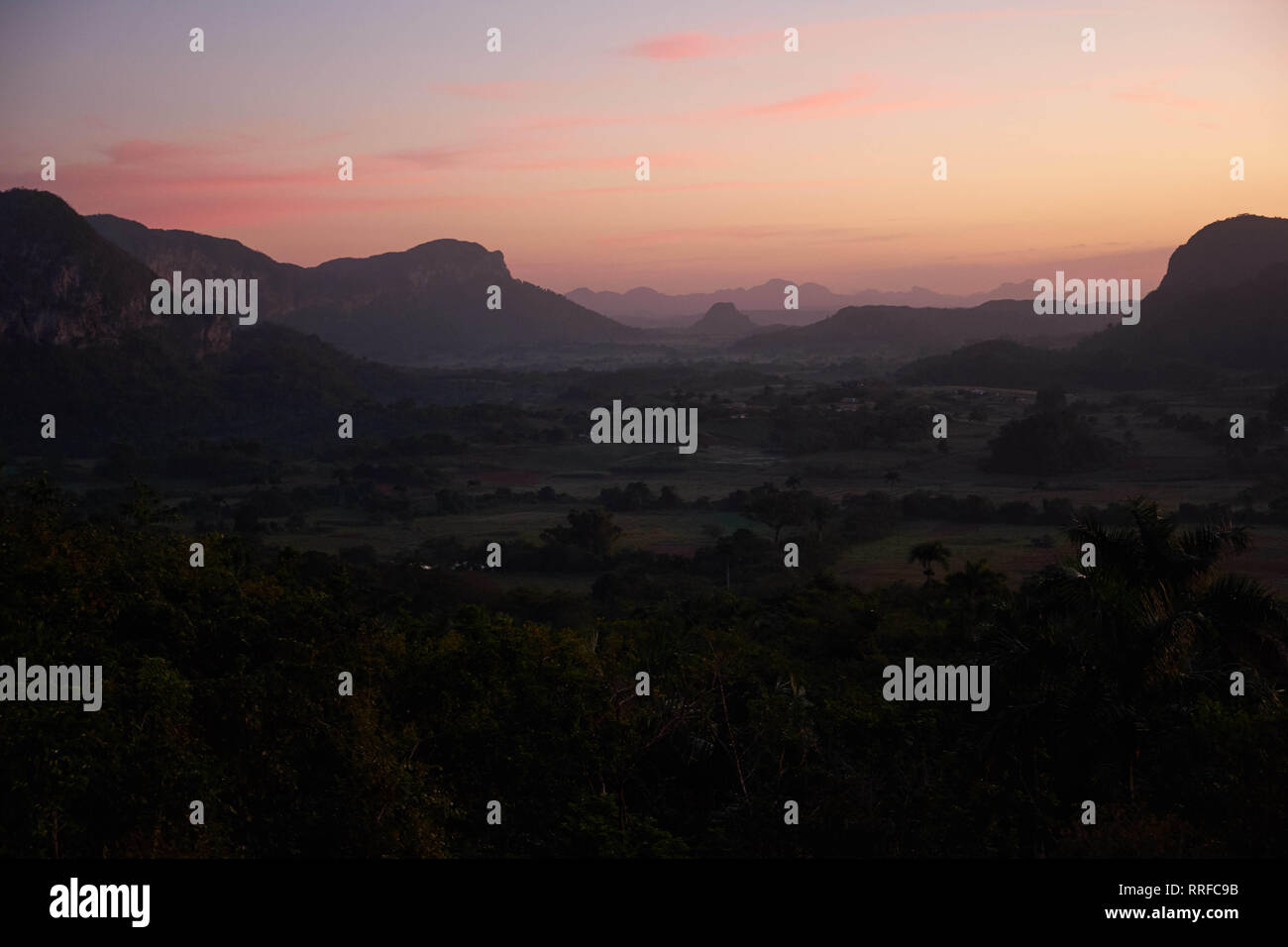 Herrliche Aussicht auf das Tal mit Wald, zwischen Hügeln und schönen rosa Himmel am Abend in Kuba Stockfoto