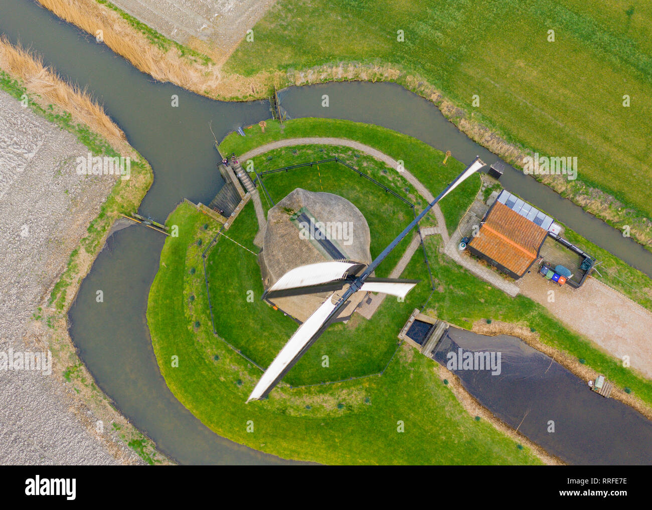 Typische holländische Windmühle aus dem 17. Jahrhundert Schuß von oben mit einer Drohne durch einen Kanal in den Bereichen Holland umgeben Stockfoto