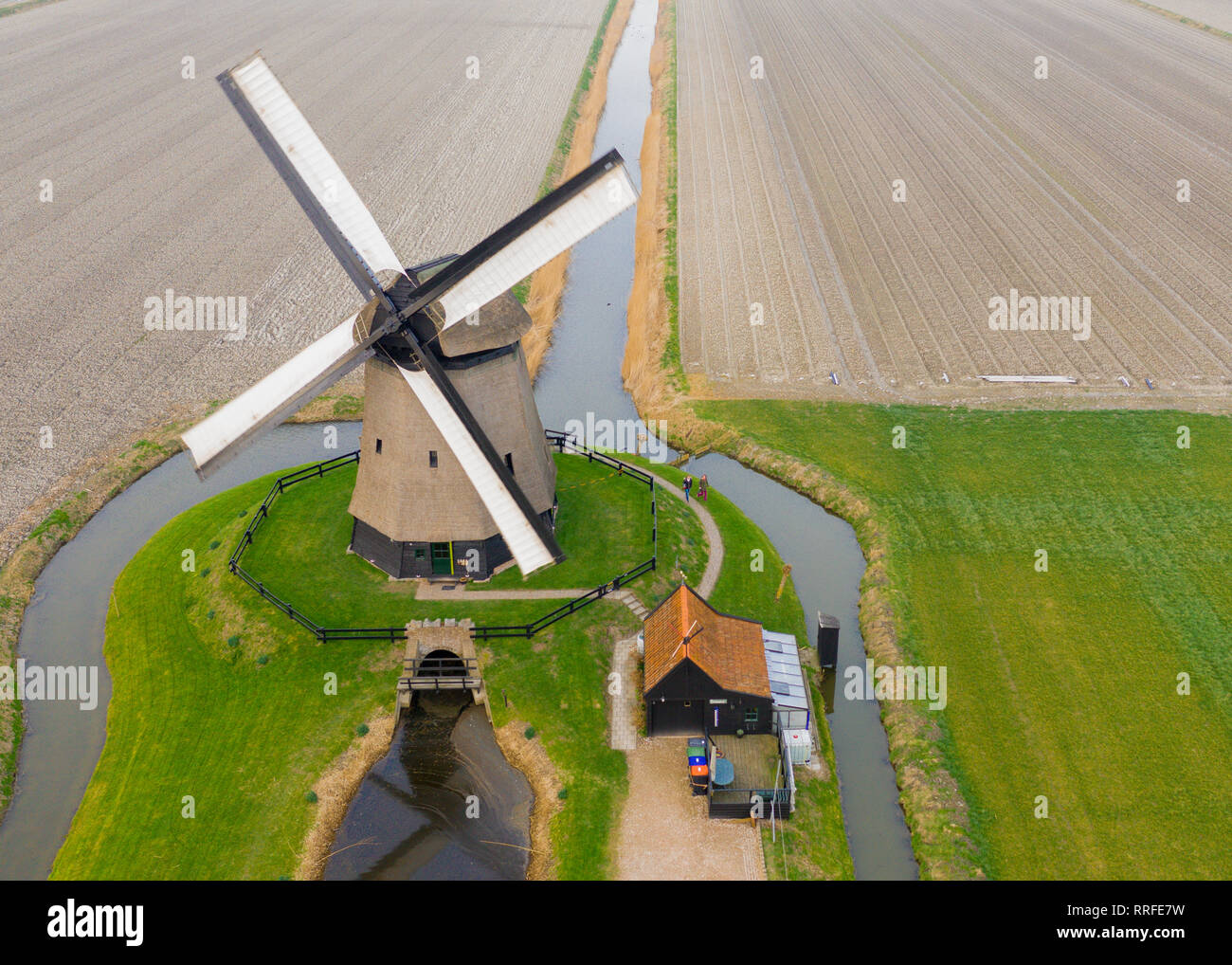 Typische holländische Windmühle aus dem 17. Jahrhundert Schuß von oben mit einer Drohne durch einen Kanal in den Bereichen Holland umgeben Stockfoto
