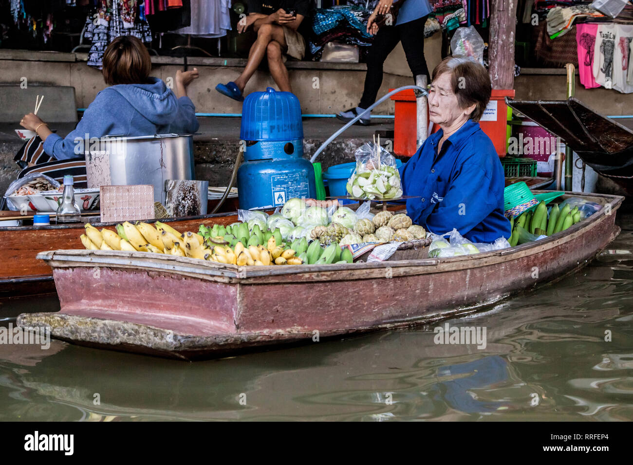 Damnoen Saduak, Thailand - 29. August 2018: Frau verkaufen Früchte von einem Boot in Damnoen Saduak Markt, Ratchaburi, Thailand. Stockfoto