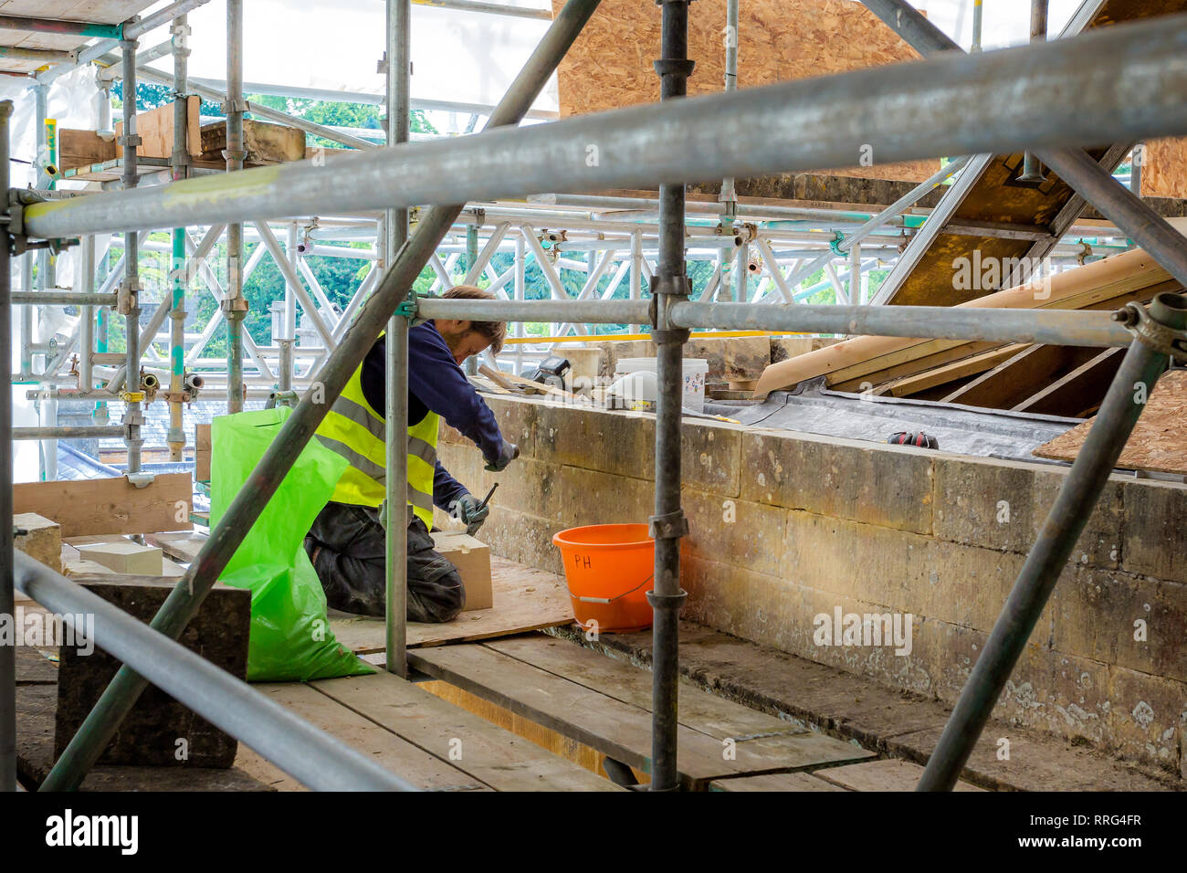 Steinmetz bei der Arbeit an großen Dach Renovierung historischer Gebäude an Dyrham Park, Gloucestershire, UK am 8. September 2015 Stockfoto