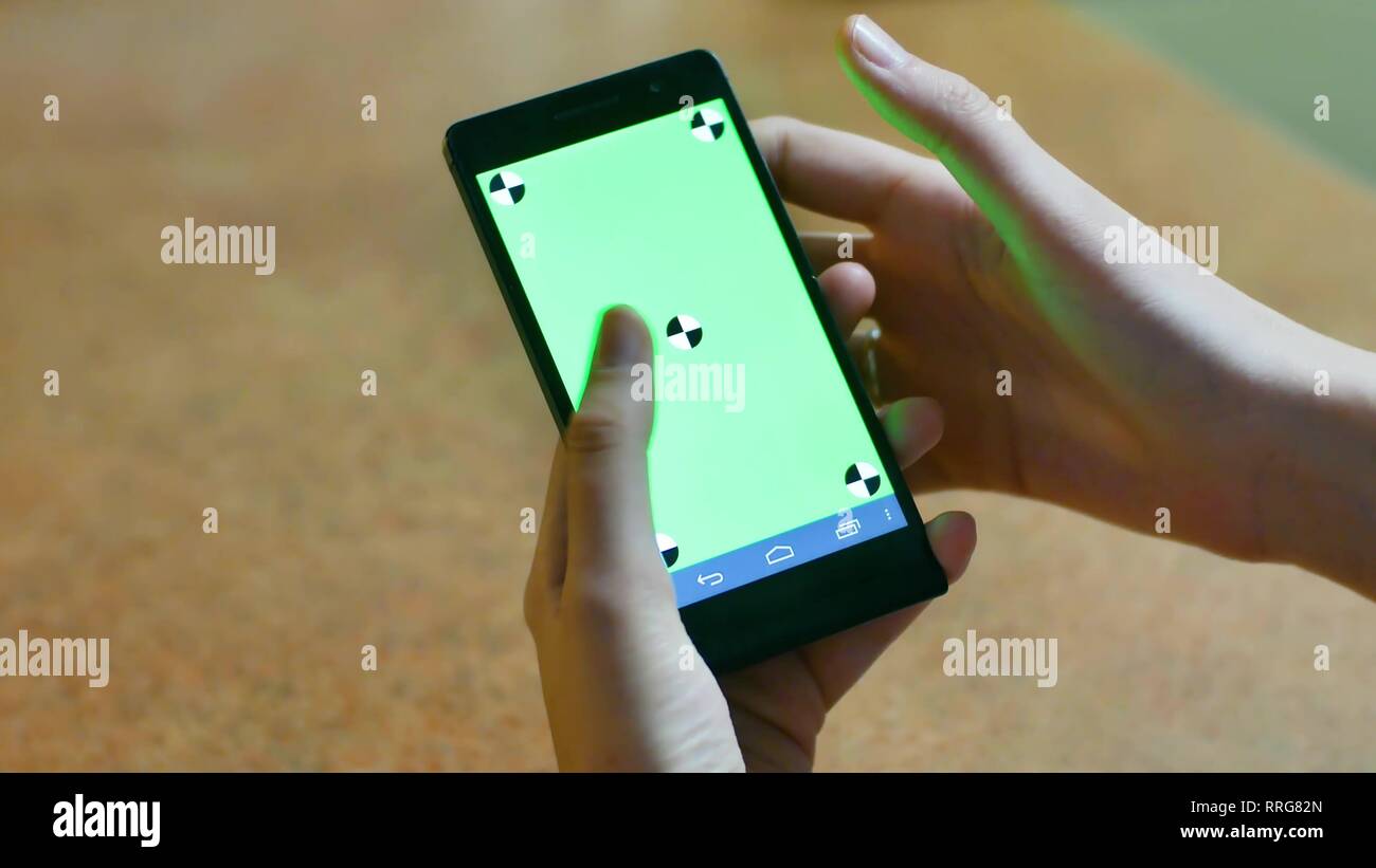 Womans Hände mit einem Smartphone Touchscreen Chroma Key Close-up, Finger, Gesten, Berührungen und über den Bildschirm wischen, einer modernen Smartphone. Stockfoto