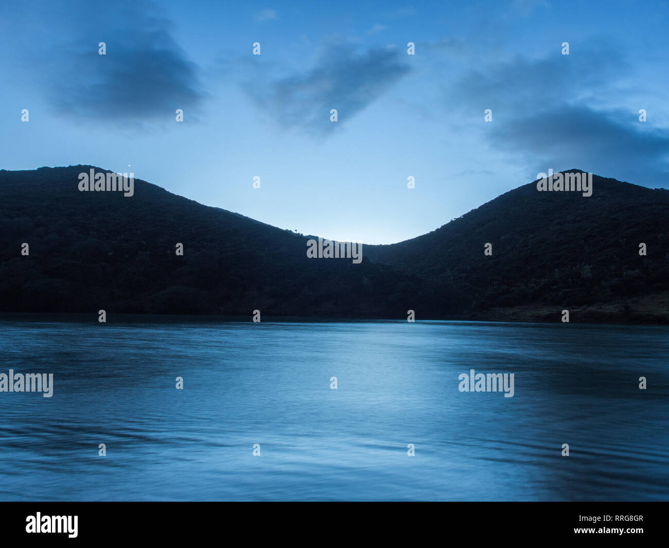 Das dunkle Land zwischen Himmel und Meer, am frühen Morgen, Winter, Tapotupotu, Northland, Neuseeland Stockfoto