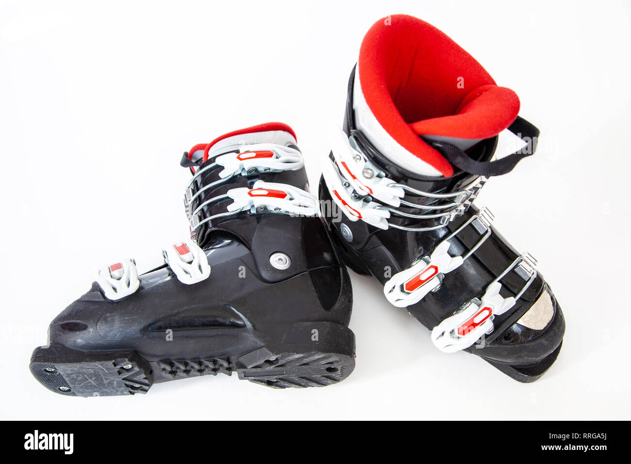 Ein Paar rote und schwarze Alpine ski Stiefel auf weißem Hintergrund. Stockfoto