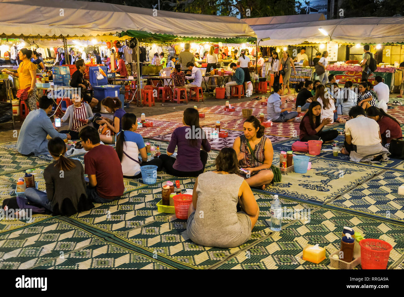 Die Leute sitzen auf Matten das Essen an den bunten Phsar Kandal Nacht Markt in der Nähe des Flussufers, Stadtzentrum, Phnom Penh, Kambodscha, Indochina Stockfoto