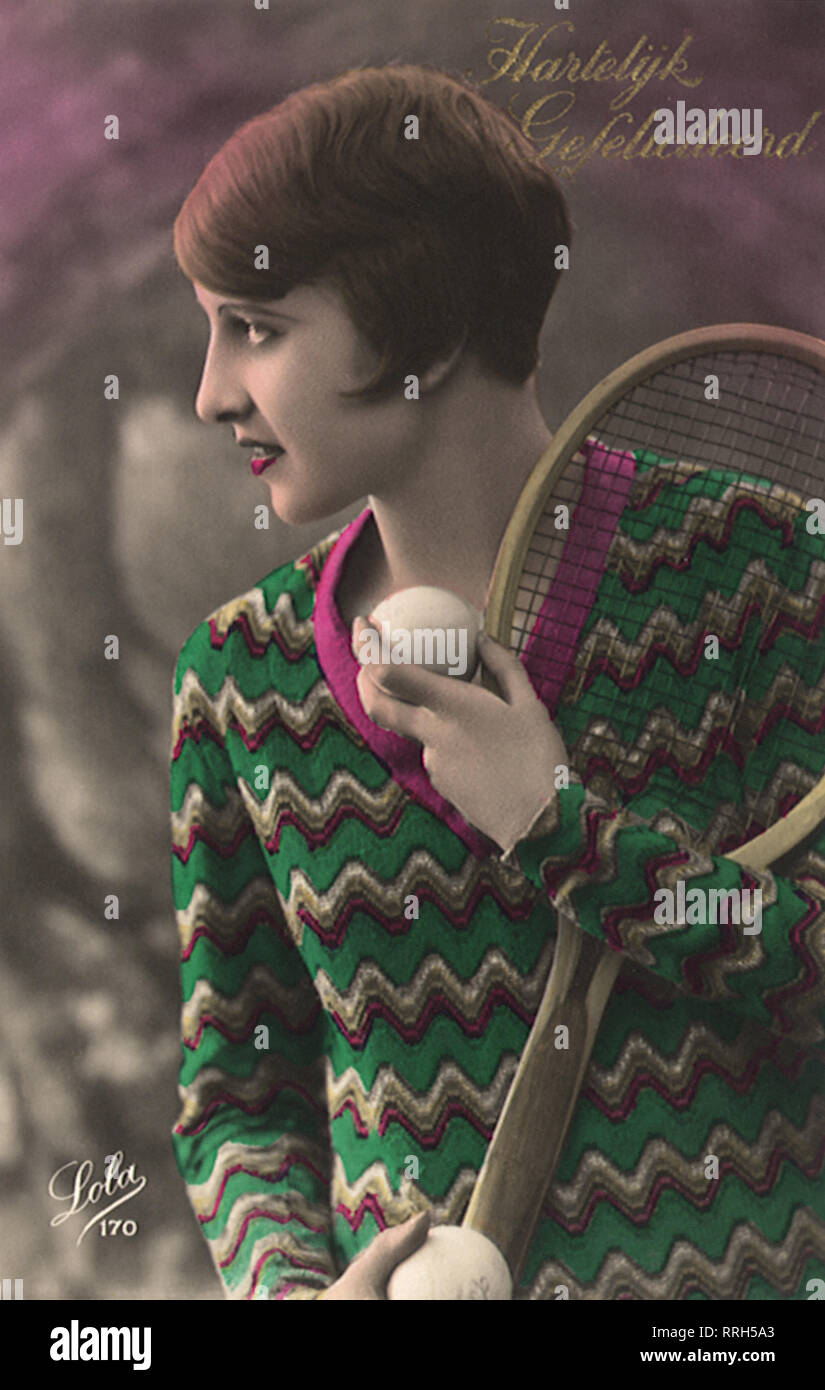 Frau mit kurzen Haaren & Pullover mit Tennisschläger und Ball. Stockfoto