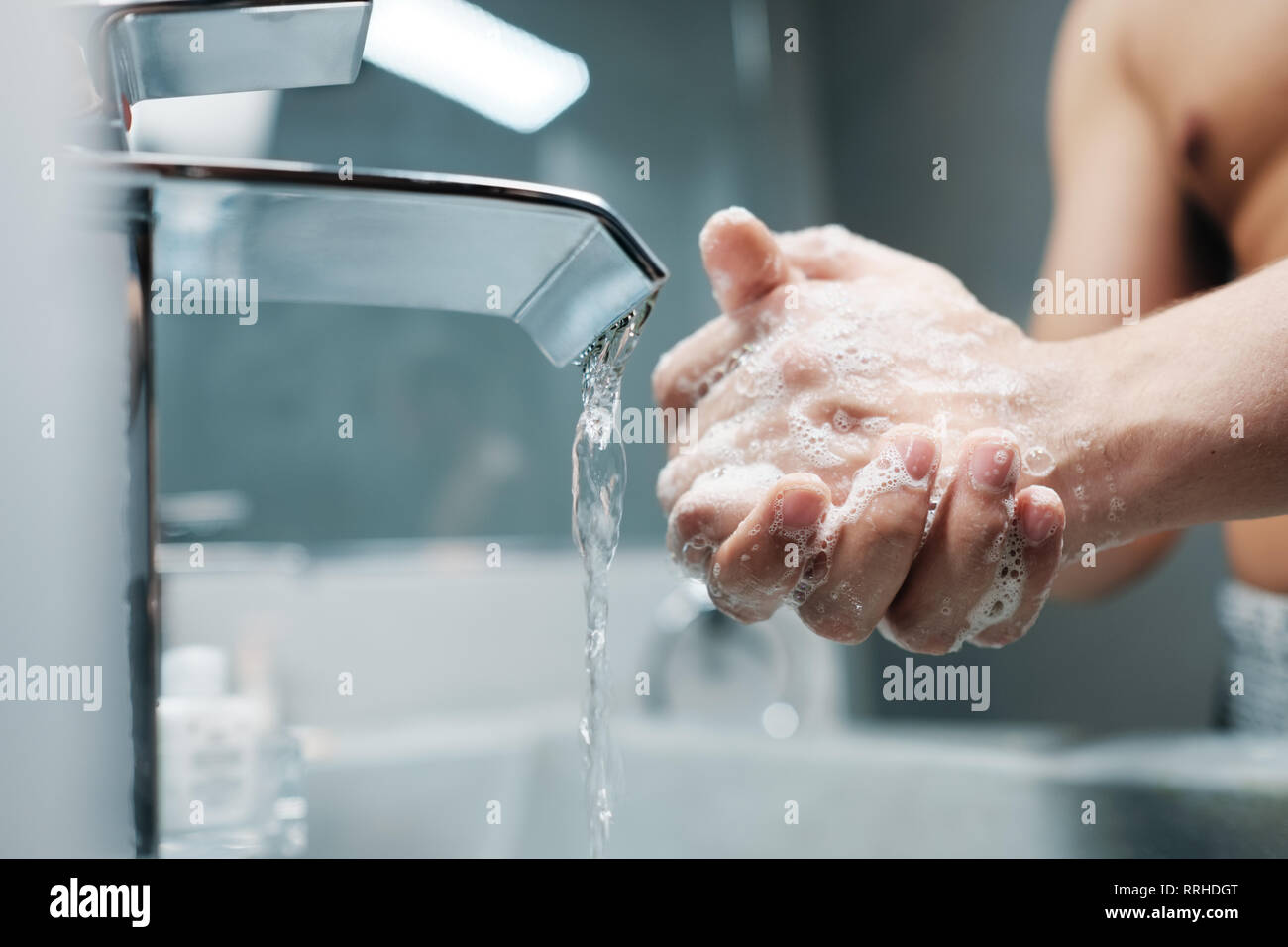 Man Waschen der Hände mit Wasser und Seife im Bad Stockfoto