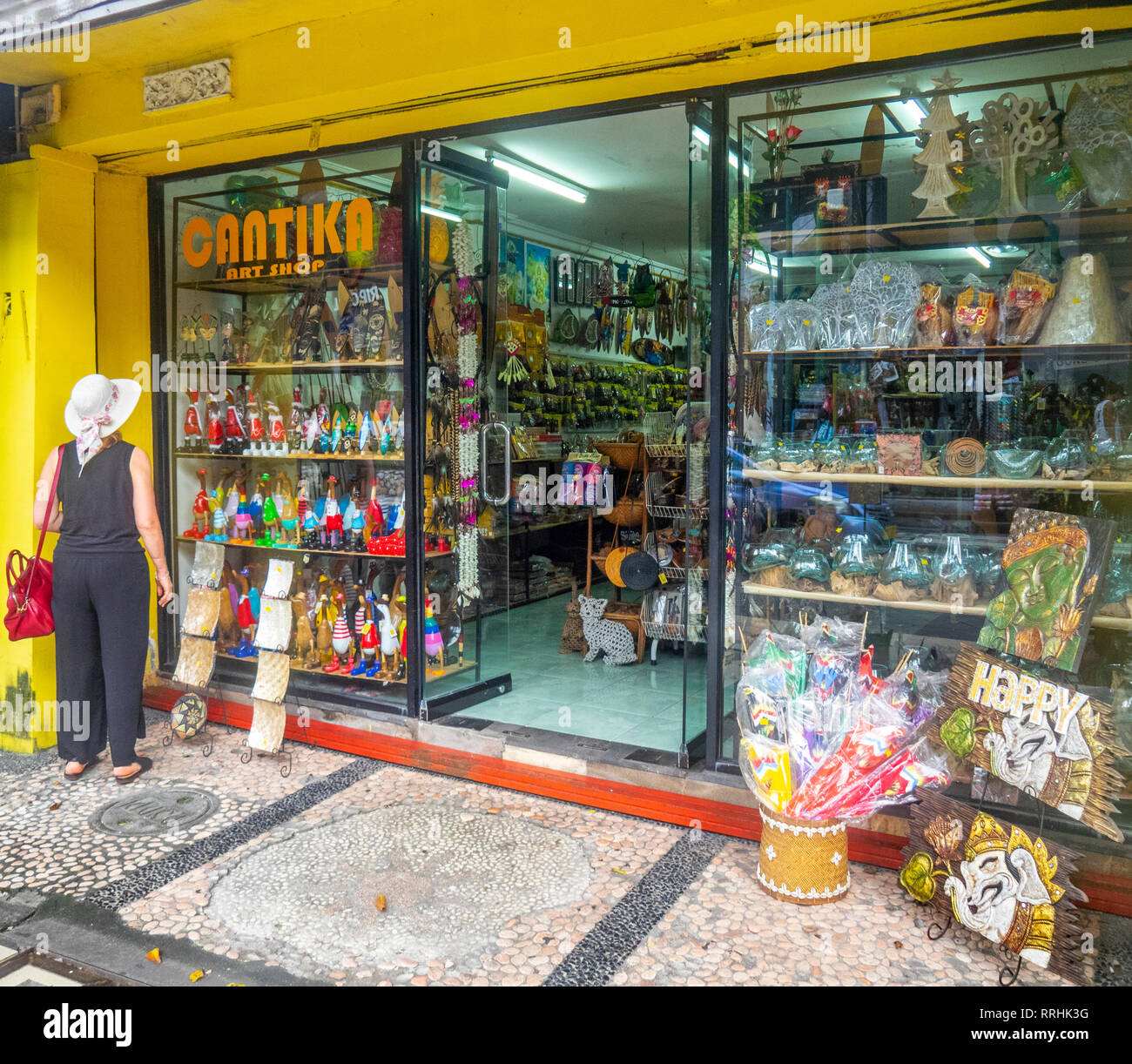 Kaukasische weibliche Touristen mit roten Tasche außerhalb einen Souvenir Shop in Kuta Bali Indonesien. Stockfoto