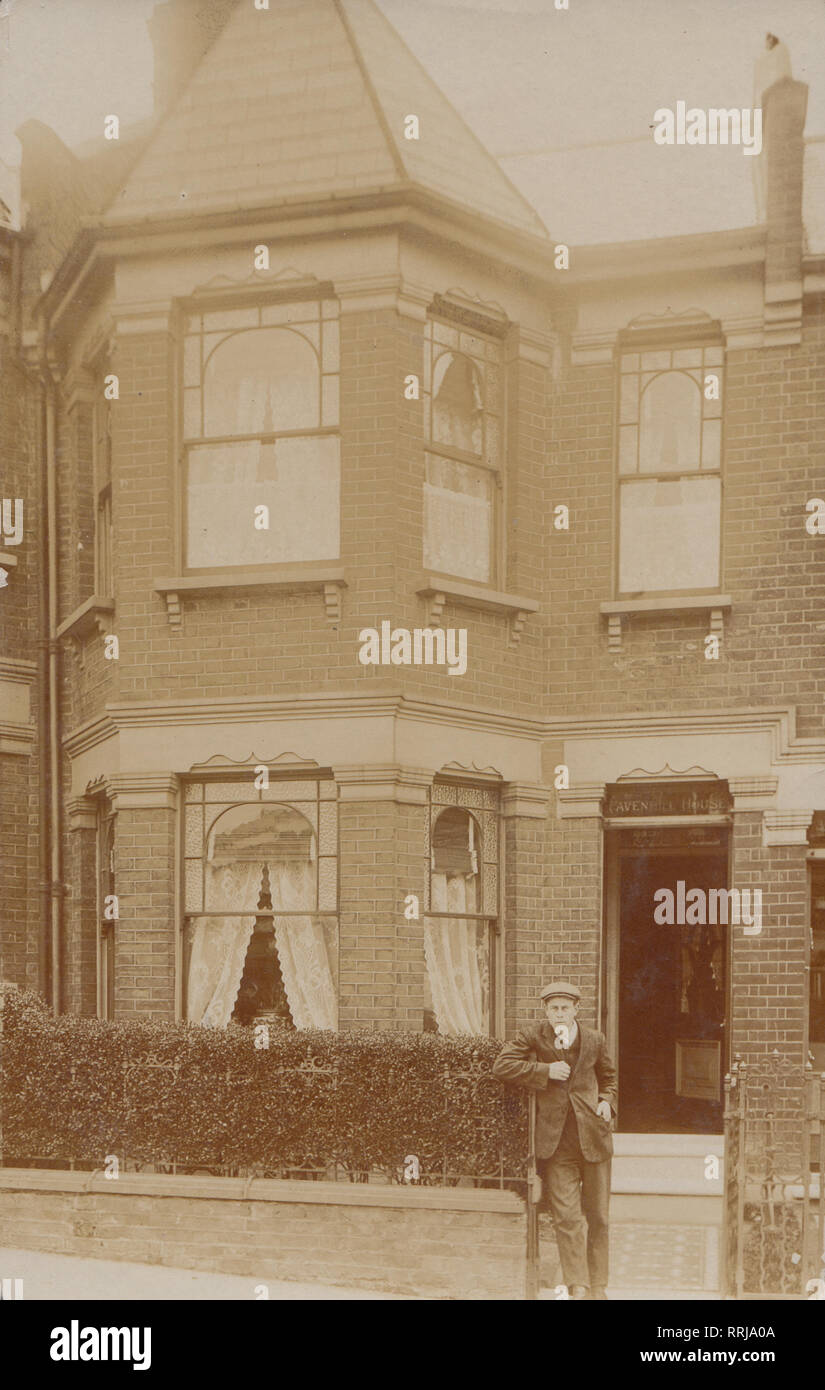 Jahrgang fotografische Postkarte zeigt eine junge edwardian Mann am Tor des Pavenhill Haus, Harcourt Road, Wood Green, London, England. Stockfoto