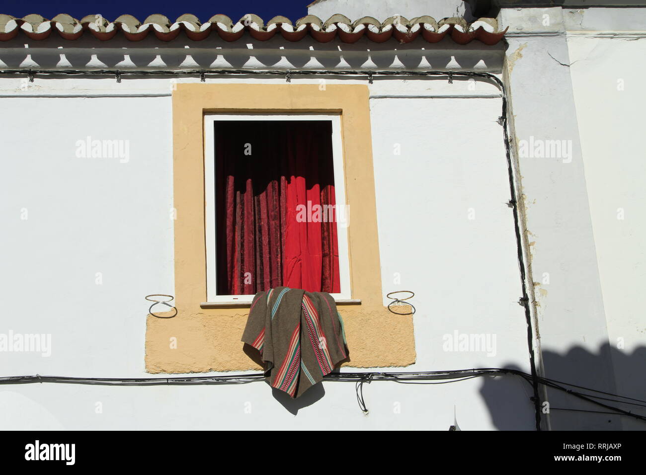 Decke drapiert über der Fensterbank, rote Vorhänge, gelb Verkleidung,  Évora, Alentejo, Portugal Stockfotografie - Alamy