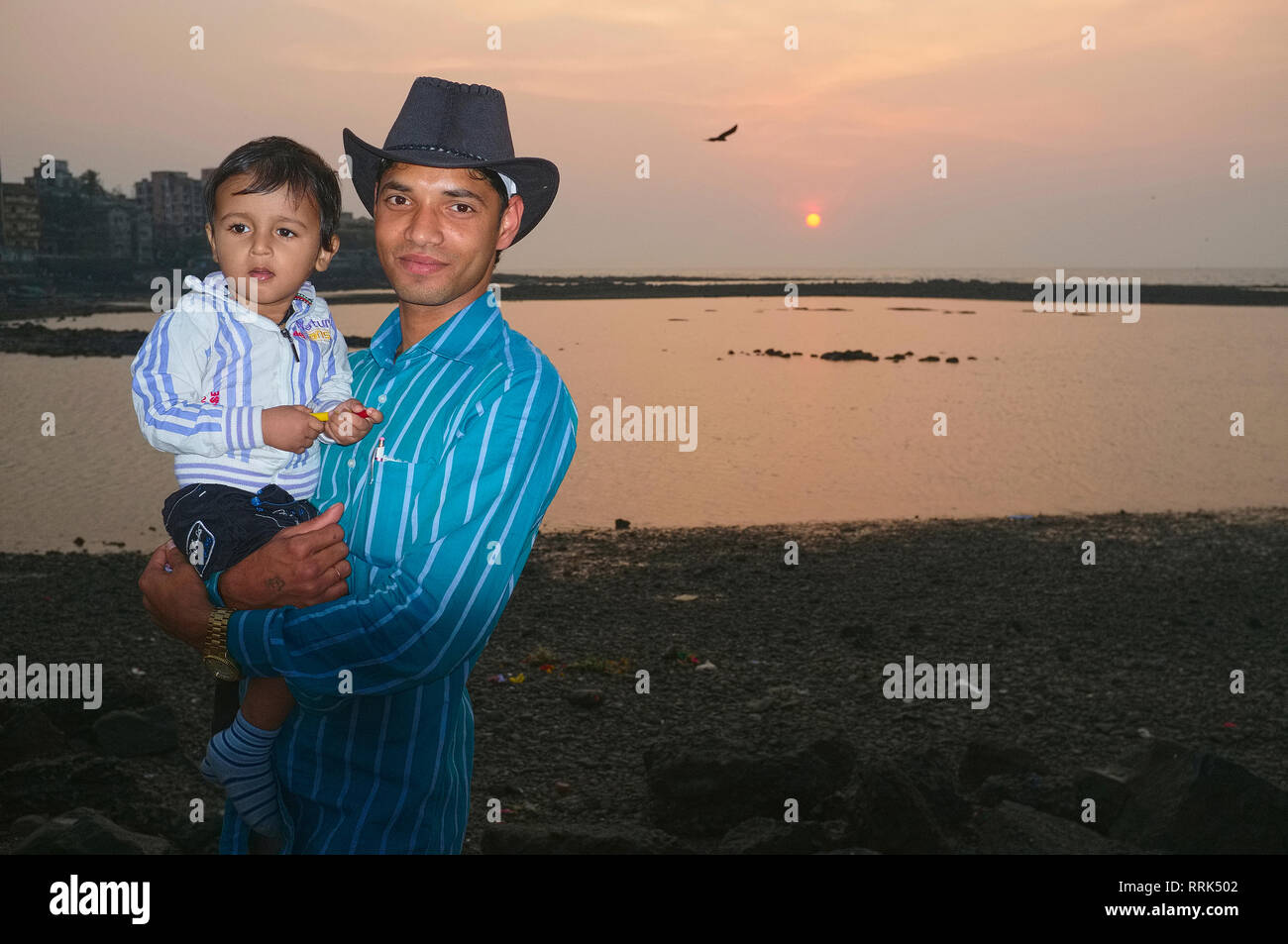 Ein junger indischer Mann und sein Sohn Sonnenuntergang durch das Arabische Meer, in Worli, Mumbai, Indien Stockfoto
