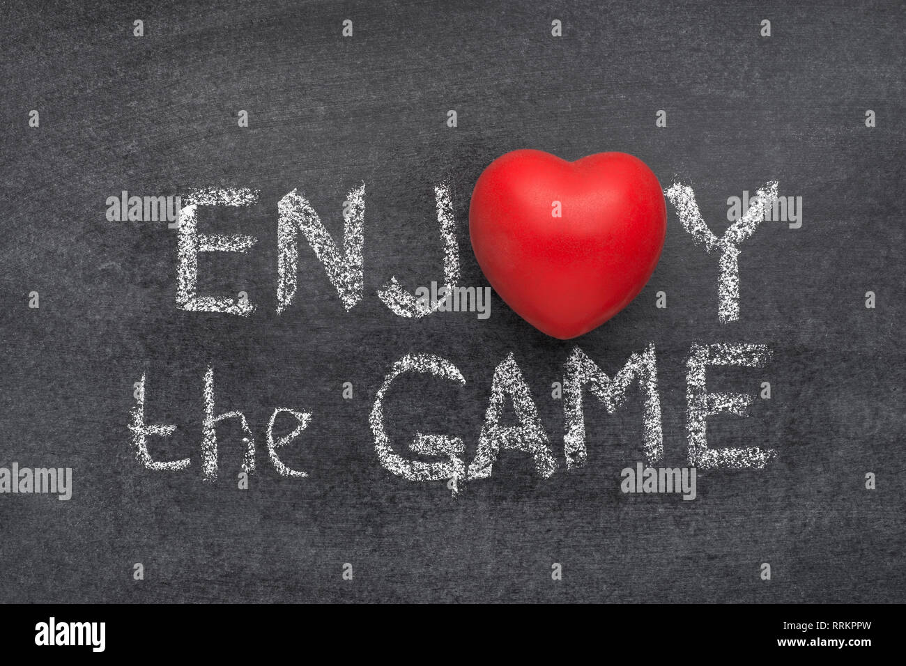 Das Spiel genießen Phrase handgeschrieben auf Tafel mit Herz statt O Stockfoto