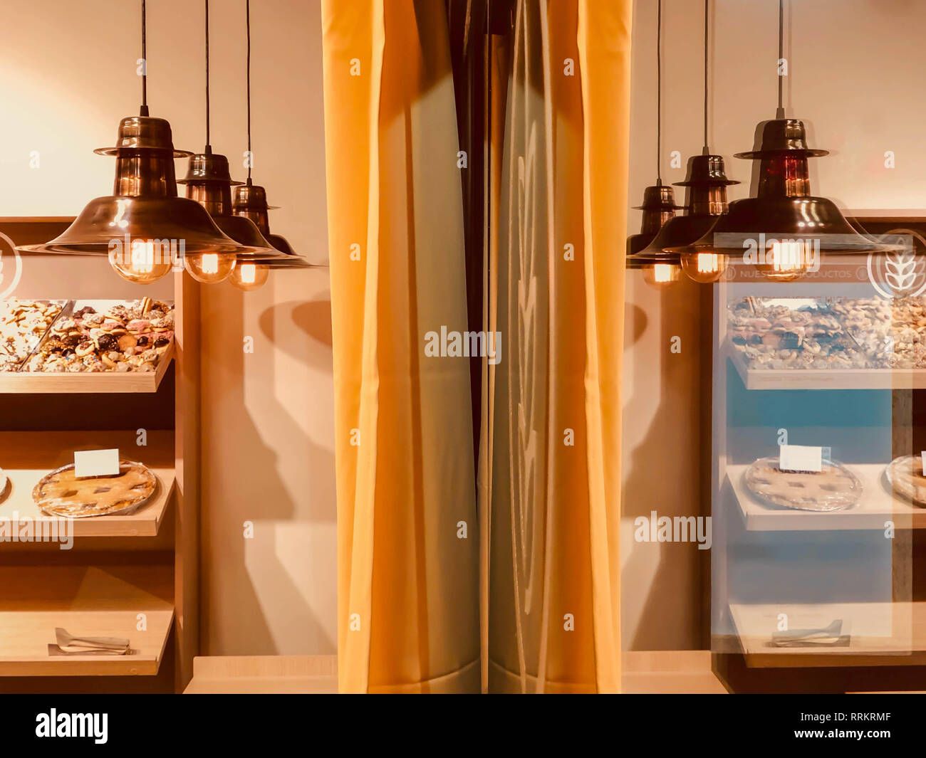 Vintage Lampen und Essen auf Unterstände auf eine Bäckerei Glas reflektiert Stockfoto