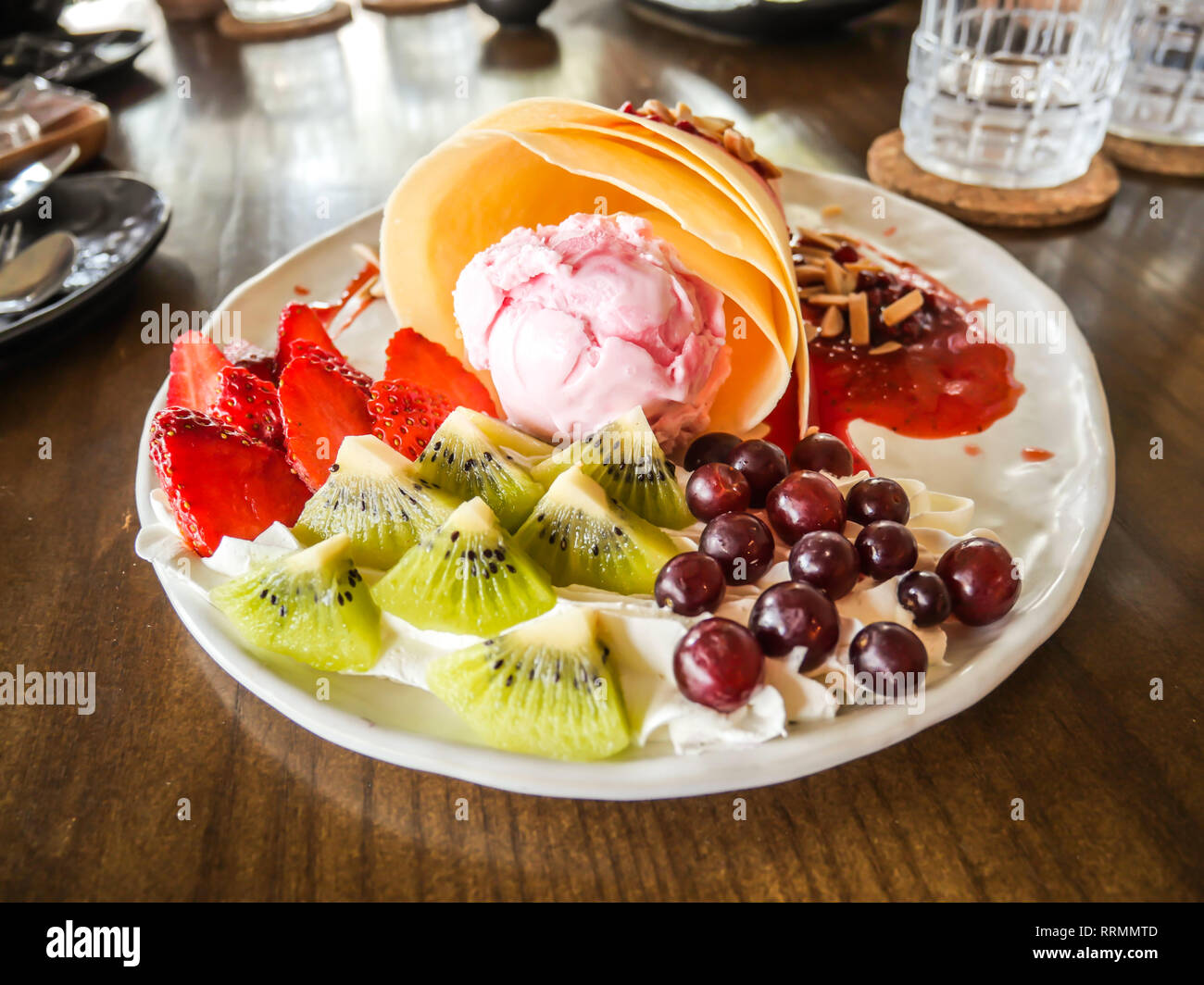 Lecker lecker hausgemachte Pfannkuchen mit Erdbeereis, Crepes gefüllt mit Erdbeeren, Kiwi, Trauben Stockfoto