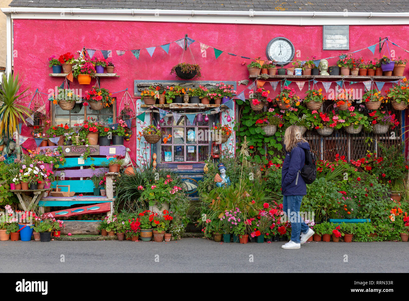 Touristen bewundern die sehr bunte Dekoration und Pflanzen schmücken ein Haus außen in Eidechse, Cornwall, Großbritannien Stockfoto