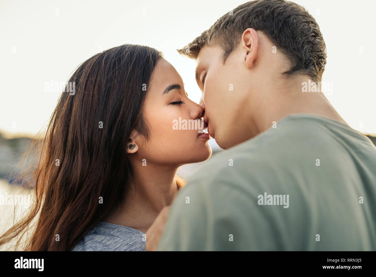 Romantische junge Paar küssen einander außerhalb am Nachmittag Stockfoto
