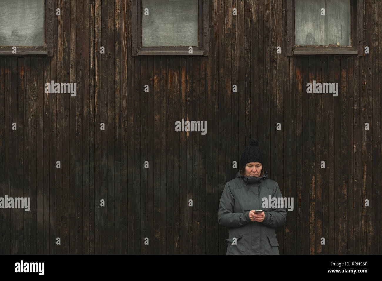 Frau mit Handy Sms draußen auf der Straße in der Kälte des Winters Tag zu senden Stockfoto