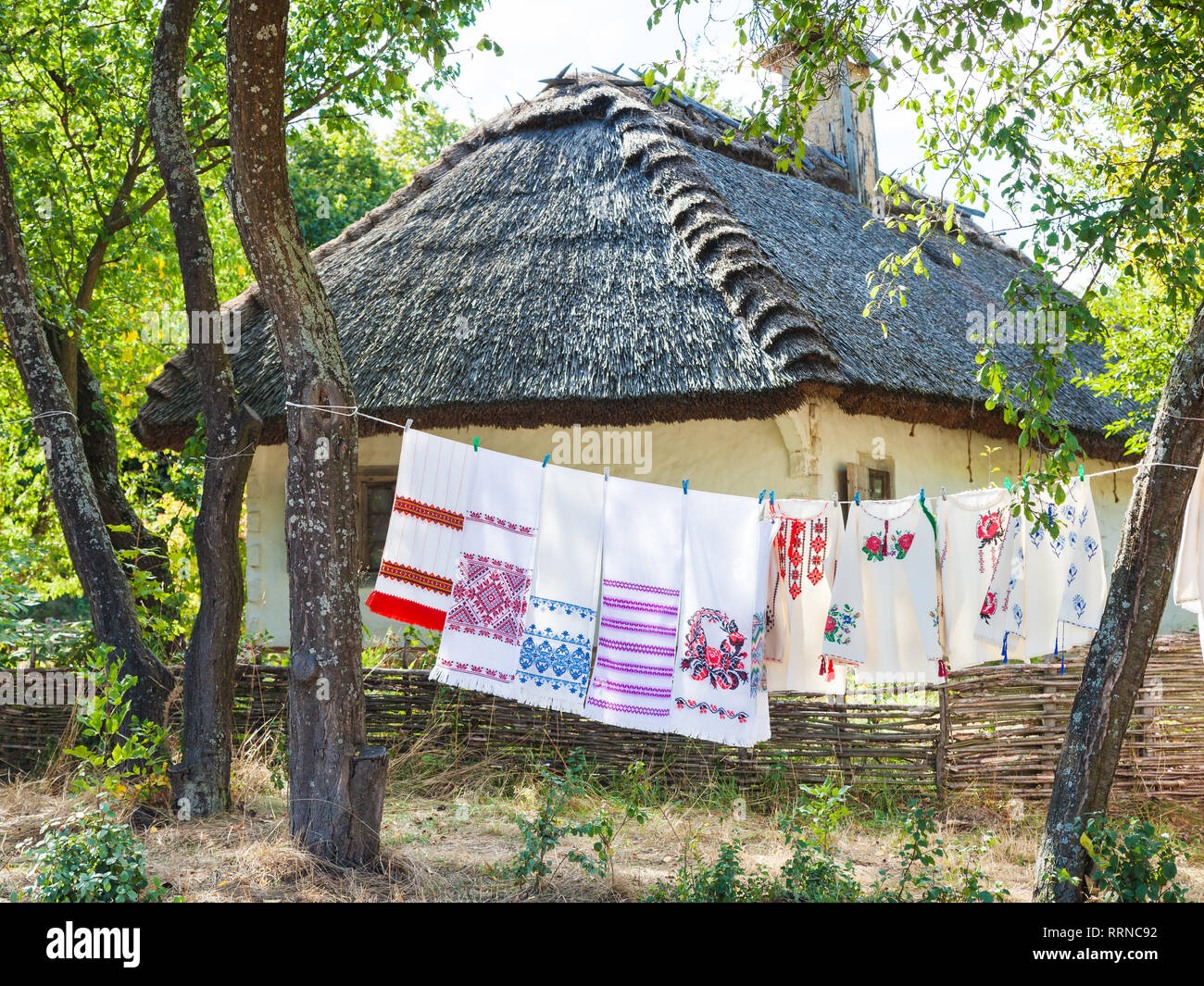 Retro ukrainischen Cottage. Traditionelle bestickte Shirt und Handtücher hängen auf der Wäscheleine. Pirogowo Dorf, Kiew, Ukraine. Stockfoto