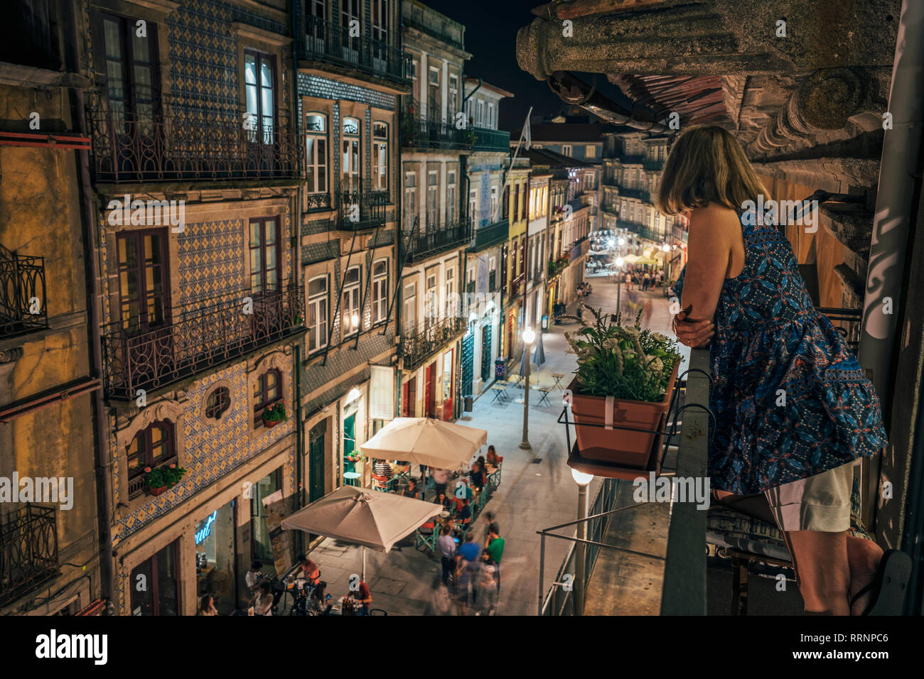 Frau, die auf dem Balkon, auf der Suche nach kunstvoller Architektur, Porto, Portugal Stockfoto