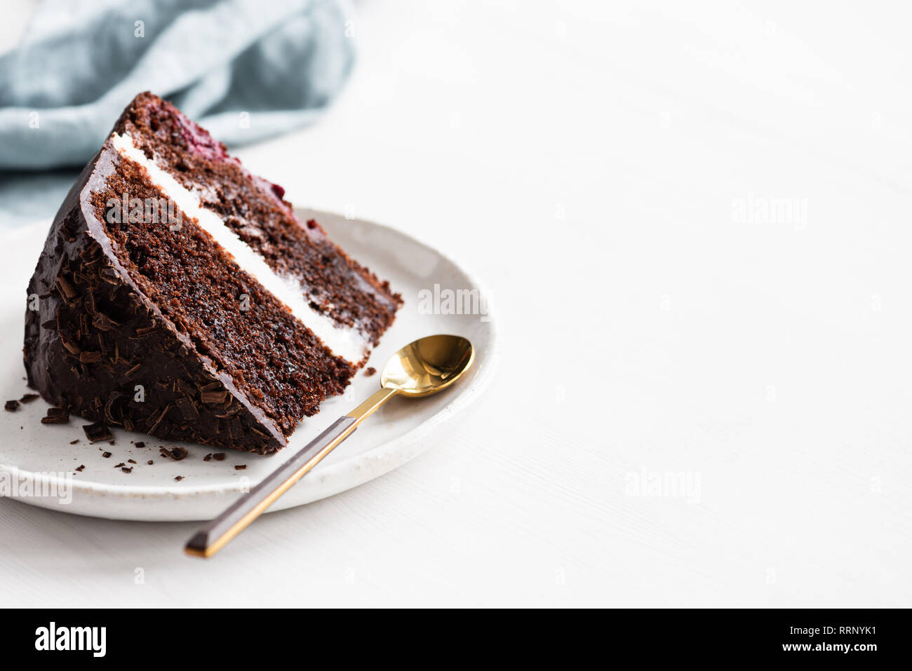Stück dunkle Schokolade Kuchen auf weiße Platte auf weißem Holz- Hintergrund. Platz für Text, Rezeptur kopieren, Geburtstag Stockfoto