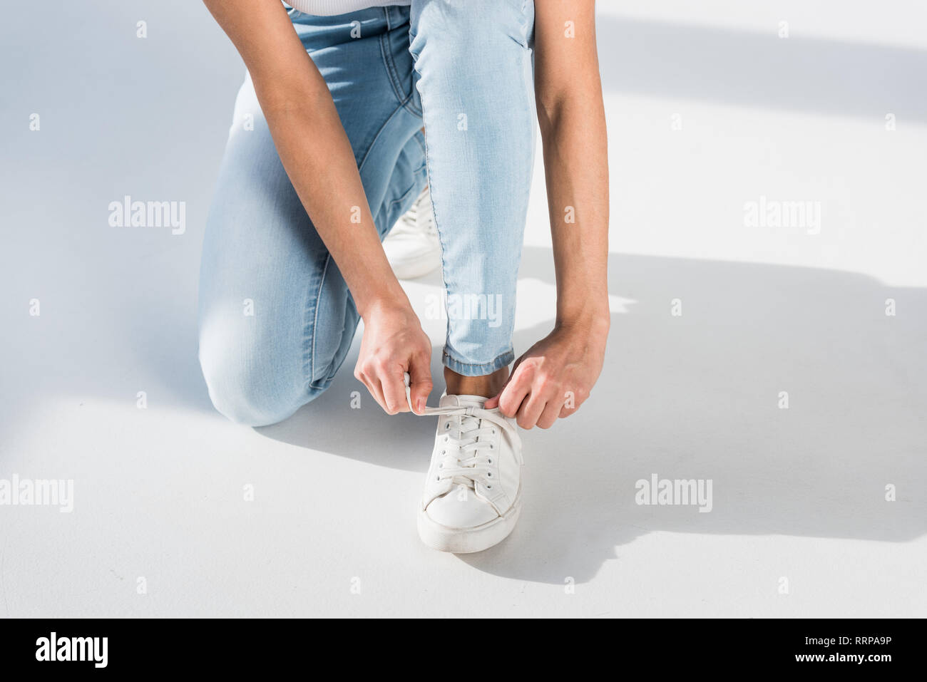 Teilweise mit Blick auf die Frau in Jeans Schnürsenkel binden  Stockfotografie - Alamy