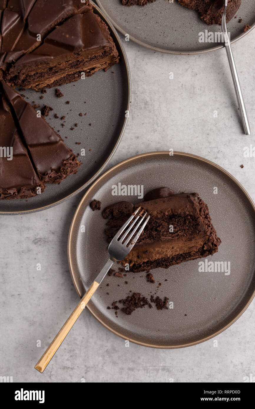 Close up geschnittene Schokolade Kuchen in Platten auf grauem Beton Hintergrund, Ansicht von oben Stockfoto