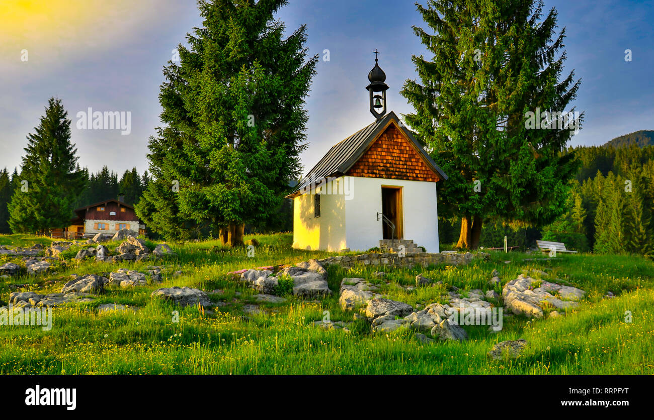 Alpenglow alp Sonnenuntergang mit kleinen Kapelle auf dem Felsen. Bergwelt in Reit im Winkl, Bayern, Deutschland. Reisen Wandern mountainclimbing Stockfoto