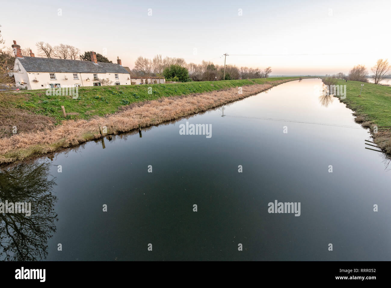 Sutton Gault, Cambridgeshire UK. 26. Februar 2019. Die New Bedford River ist komplett noch auf einer windstillen Abend nach einem ungewöhnlich warmen Tag im Februar, wo Temperaturen erreicht die hohen Teens Celsius über viel von Großbritannien. Die flache, freiliegenden Moorlandzone Landschaft in der Regel windig und kalt diese Zeit des Jahres werden aber die Unseasonal warmes Wetter hat zu einem ruhigen Abend geführt. Credit: Julian Eales/Alamy leben Nachrichten Stockfoto