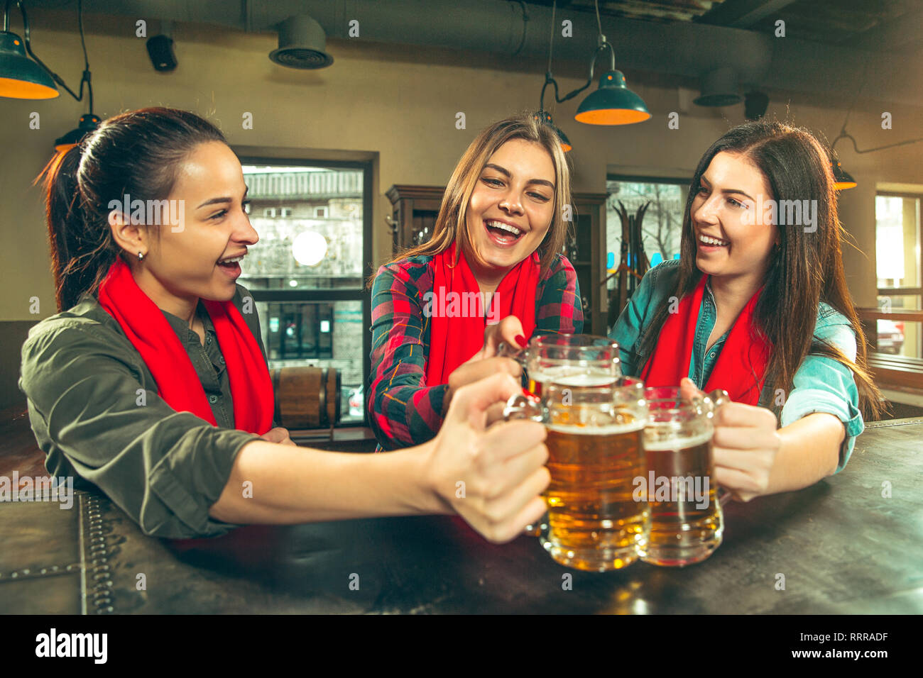 Sport, Menschen, Freizeit, Freundschaft, Unterhaltung Konzept - glückliche weibliche Fußball-Fans oder guten jungen Freunden Bier trinken, feiern Sieg an der Bar oder Pub. Die positive Emotionen Konzept Stockfoto