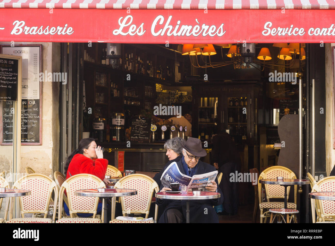 Gönner Zeitung lesen und Kaffee in der Brasserie Les Chimeres im Marais-Viertel von Paris, Frankreich. Stockfoto