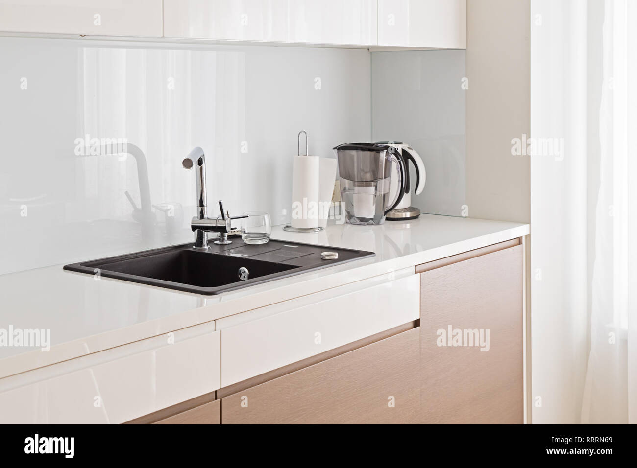 Blick auf moderne, geräumige und helle Küche mit dunklen Waschbecken und beige Schrank mit Platz kopieren Stockfoto