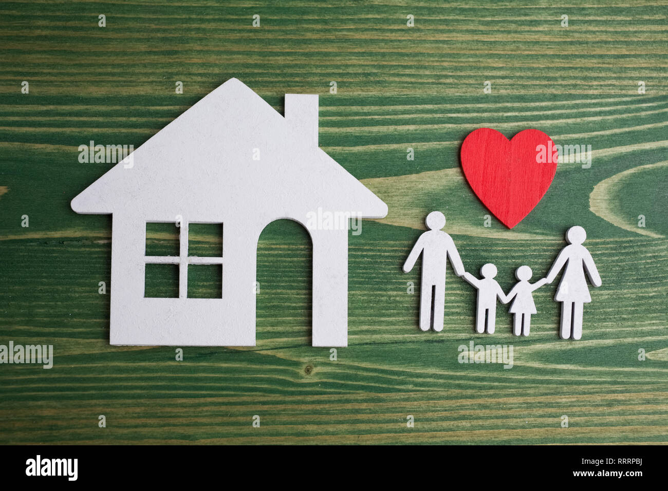 Familie Abbildung mit einem Haus am grünen Holz- Hintergrund Stockfoto