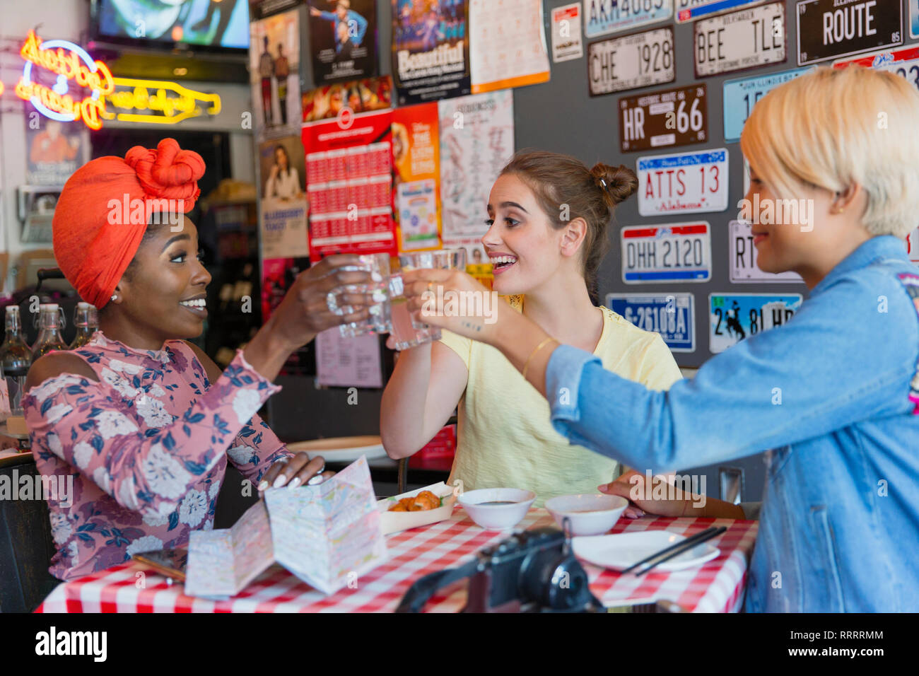 Glückliche junge Frauen Freunde toasten Cocktails in der Bar Stockfoto