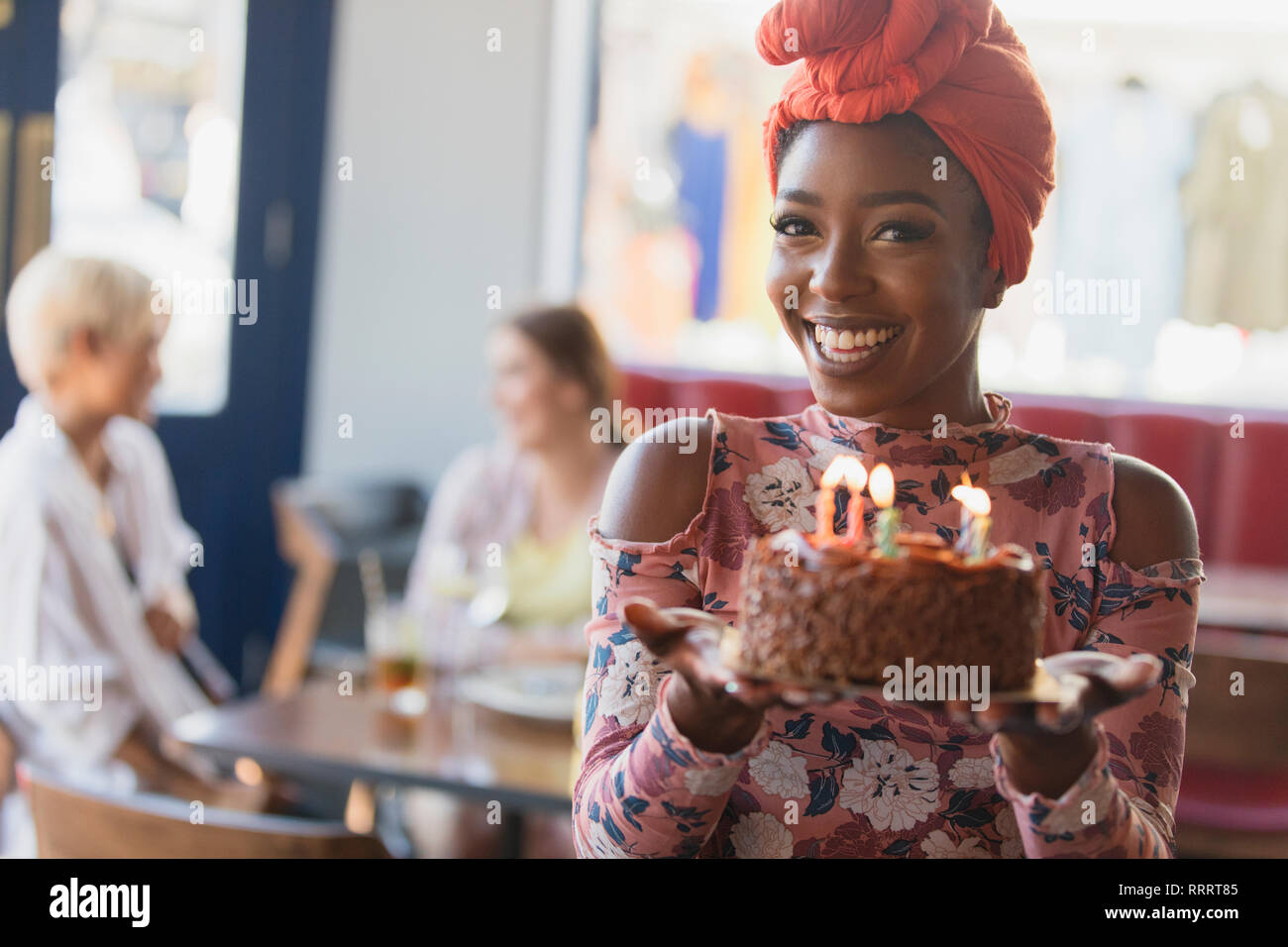 Porträt Lächeln, selbstbewusste junge Frau mit Geburtstag Kuchen mit Kerzen Stockfoto