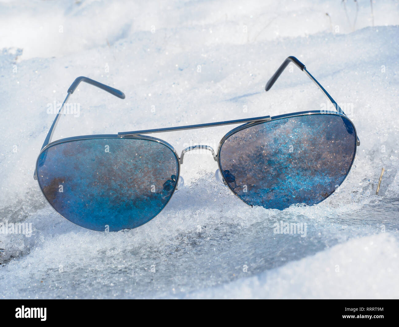 Paar blaue Sonnenbrille im Kalten vereisten Schnee, ohne ein Gesicht im Winter in der Sonne Stockfoto
