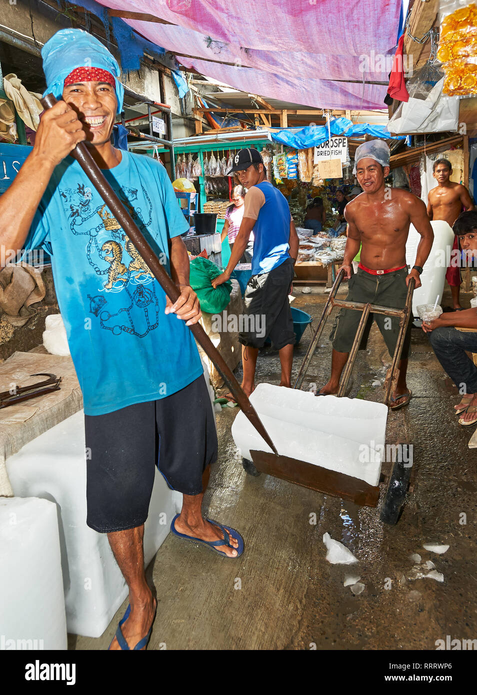 Stadt Puerto Princesa, Palawan, Philippinen - 25. Februar 2010: Portrait von jungen männlichen Arbeiter an der Wet Market bewegt riesige Eisblöcke Kunden Stockfoto