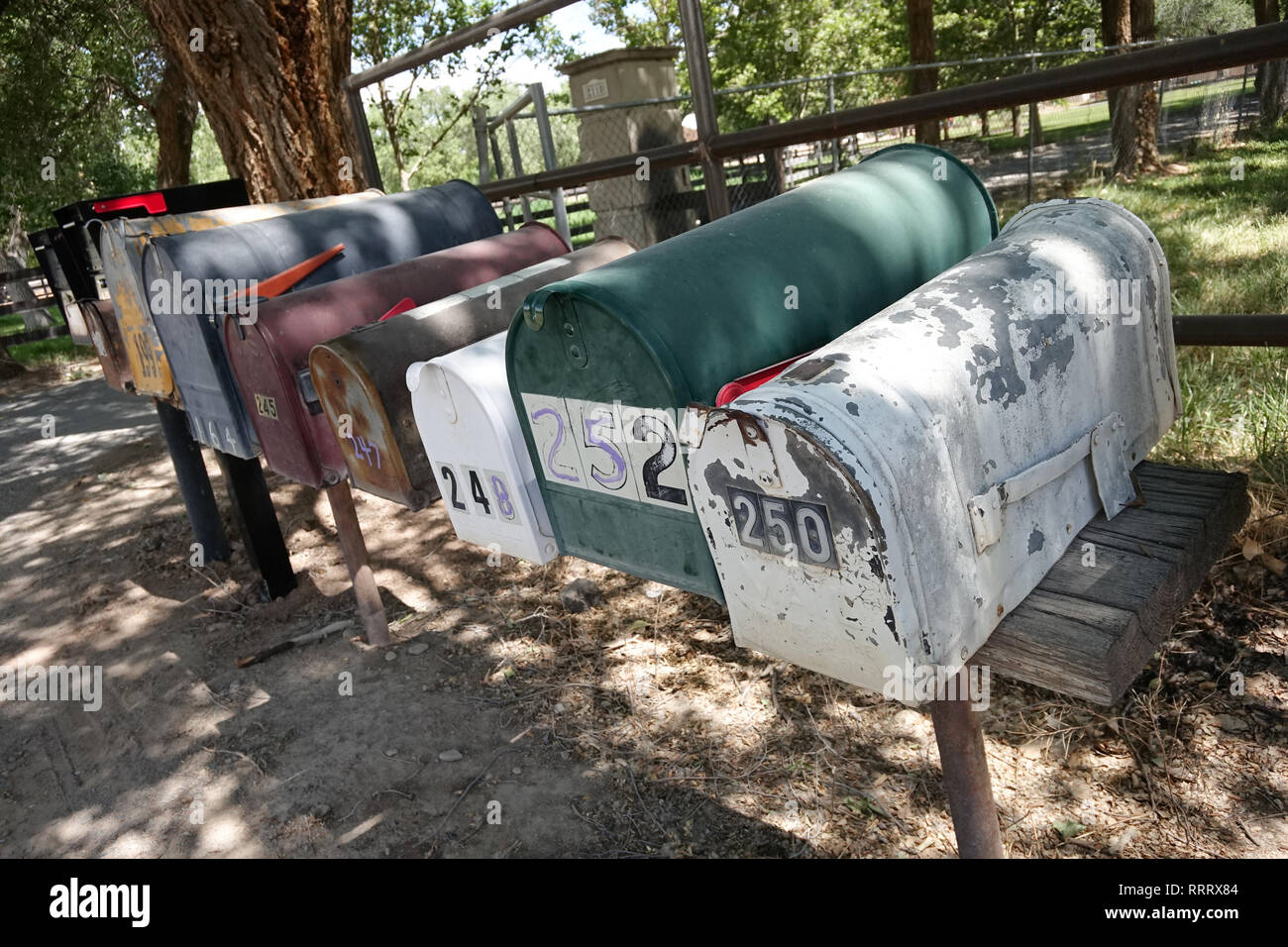 Alt, abgenutzt, Mailboxen in einer Reihe entlang einem Feldweg für Menschen, in dem das Raster aus zu leben. Stockfoto