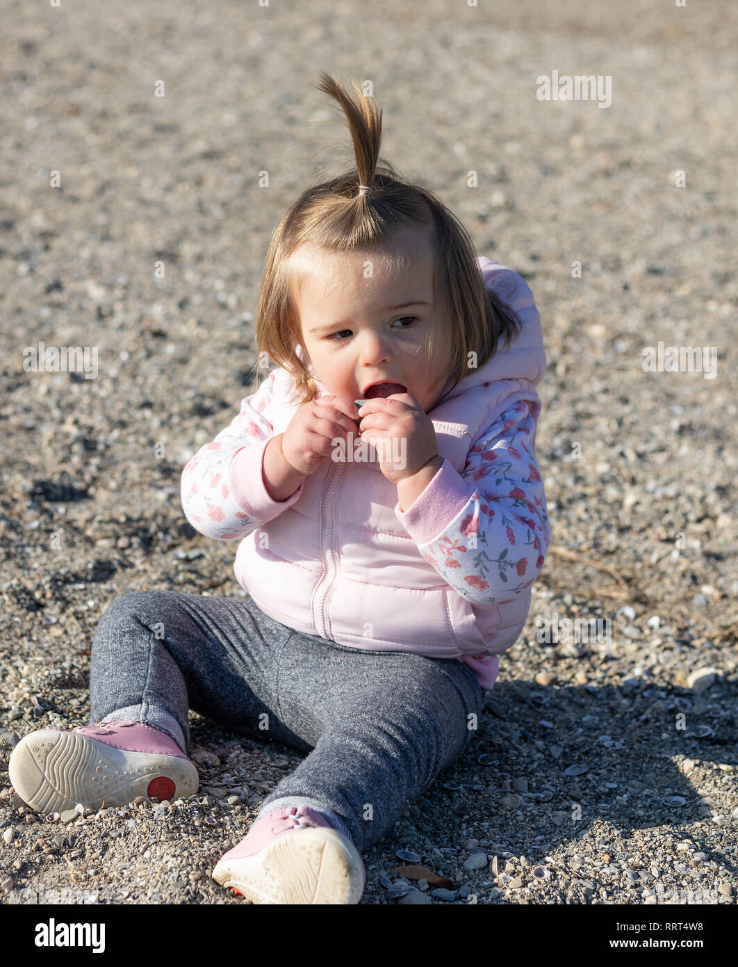 Schöne 16 Monate altes Baby Mädchen am Strand zu sitzen. Genfer See in der  Nähe der Stadt Lausanne. Schweiz Stockfotografie - Alamy