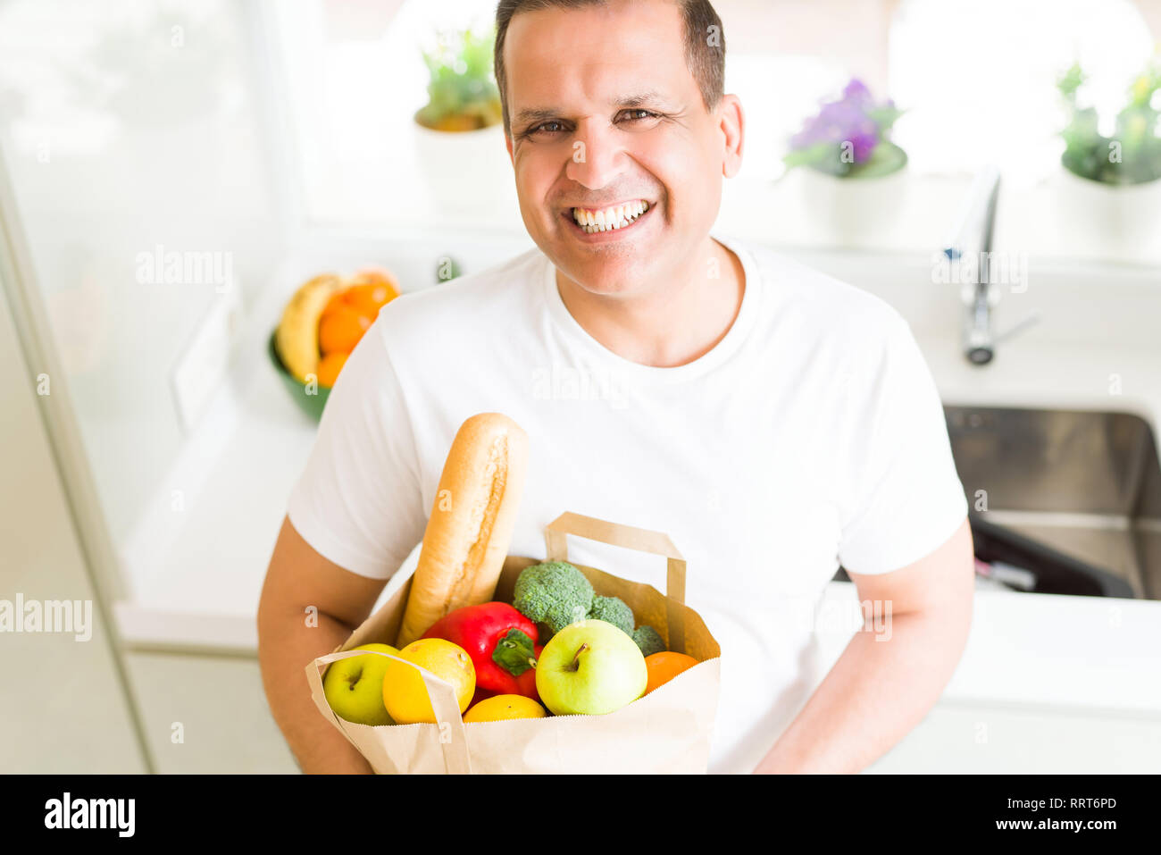 Mittleres alter Mann mit grocieries Beutel voller Gemüse zu Hause Stockfoto