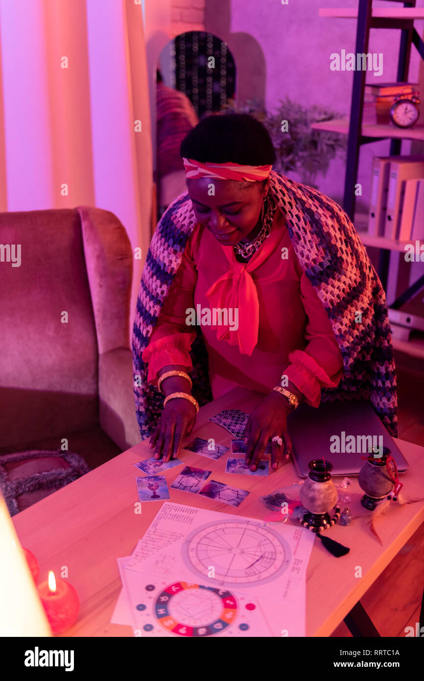 African American pralle Wahrsagerin mit riesigen Ohrringe Lesung Tarot Karten Stockfoto