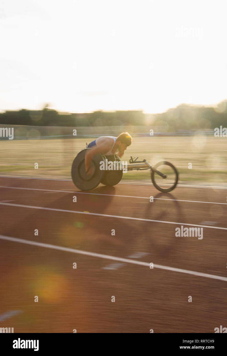 Bestimmt jungen männlichen querschnittsgelähmten Athlet Beschleunigung zusammen Sport Track im Rollstuhl Rennen Stockfoto