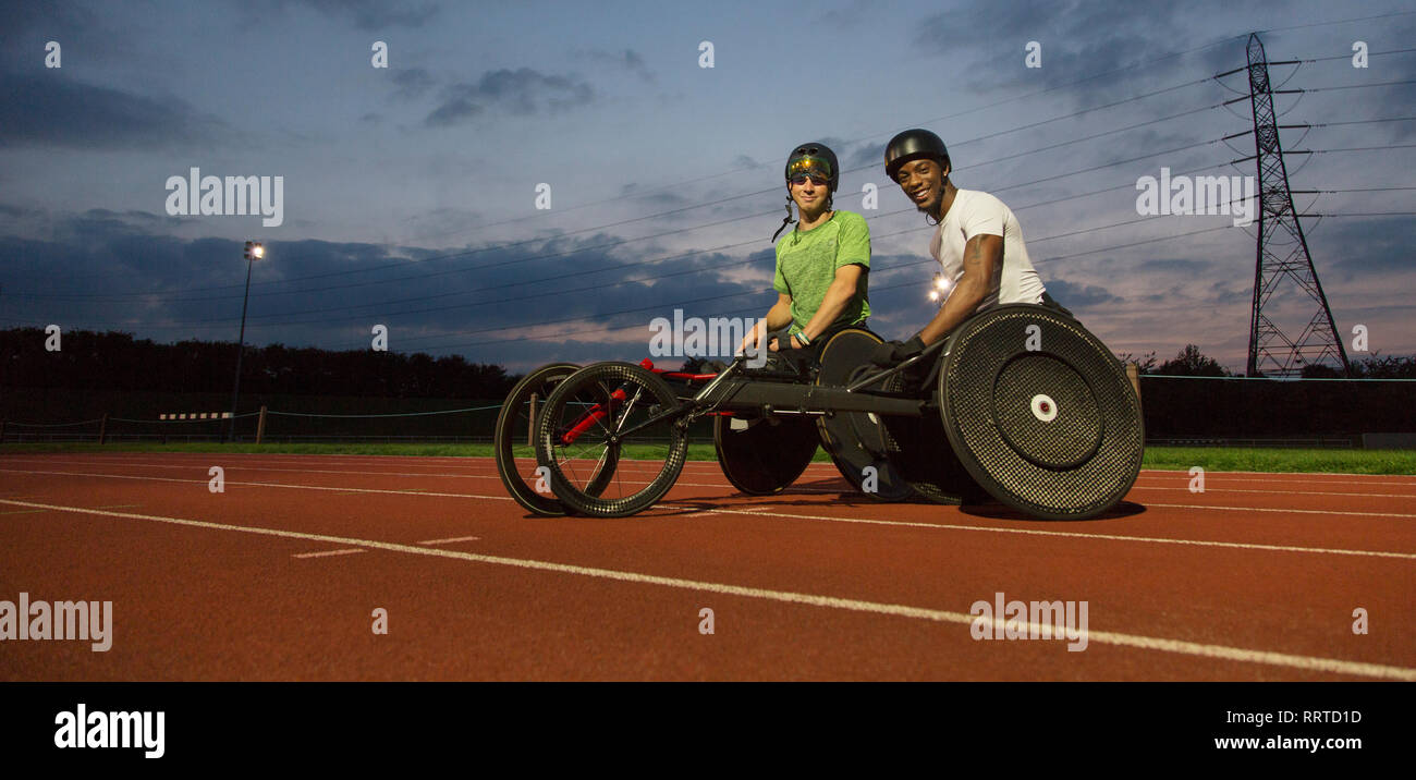 Portrait zuversichtlich, querschnittsgelähmten Athleten auf Sportplatz, Training für Rollstuhl Rennen bei Nacht Stockfoto