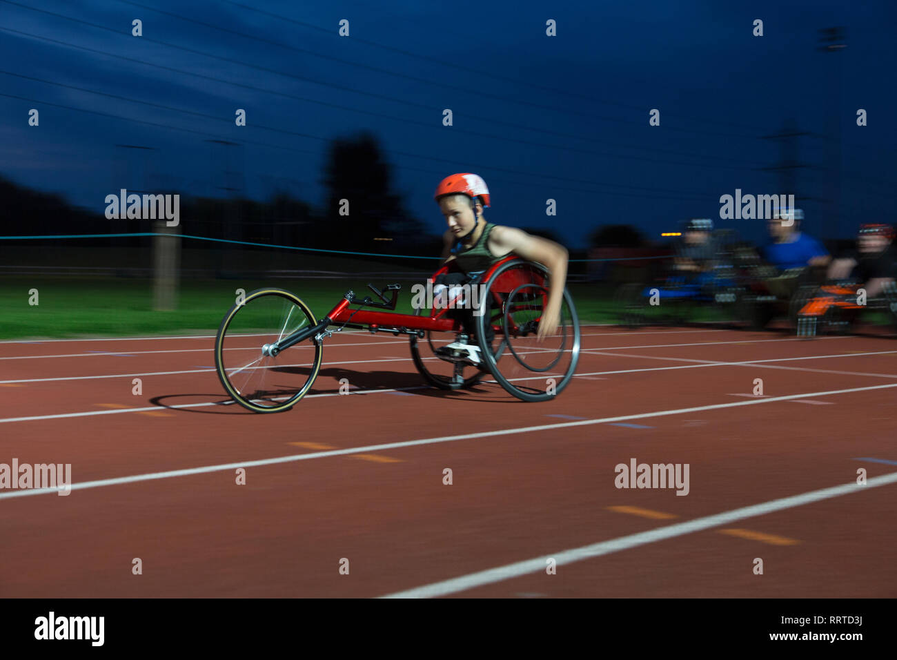 Teenage paraplegic Athlet Beschleunigung zusammen Sport Track im Rollstuhl Rennen Stockfoto