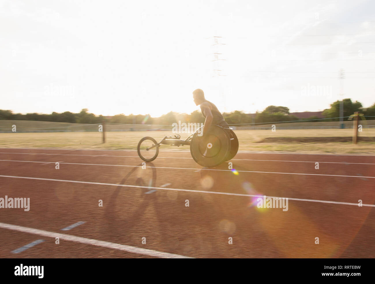 Jungen männlichen querschnittsgelähmten Athlet Training für Rollstuhl Rennen auf sonnigen Sportplatz Stockfoto