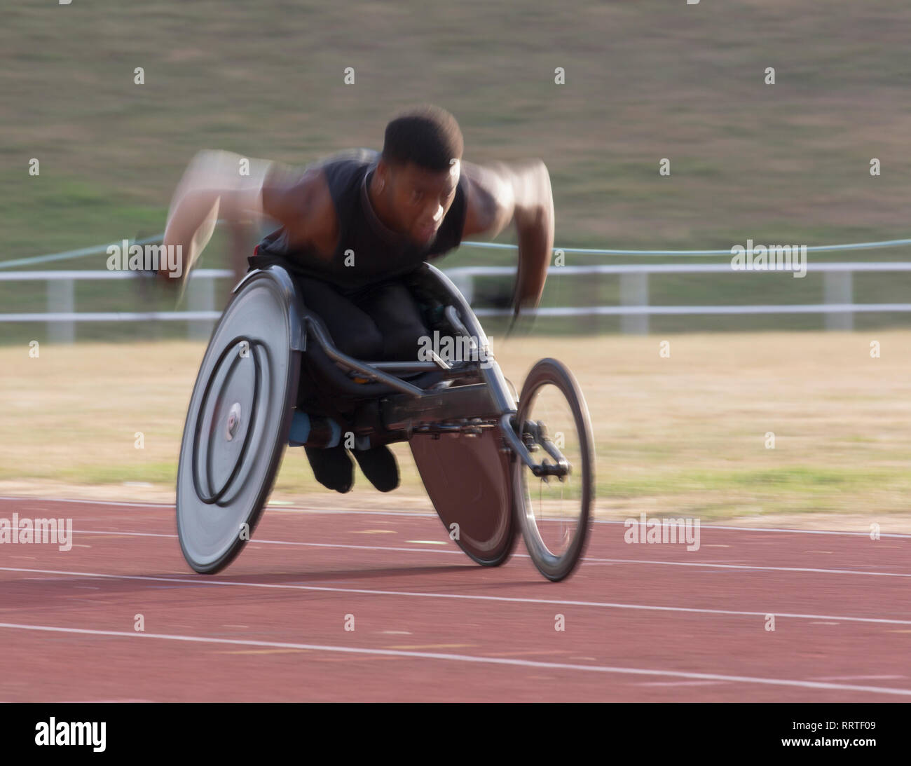 Bestimmt jungen männlichen querschnittsgelähmten Athlet Beschleunigung zusammen Sport Spur während der Rollstuhl Rennen Stockfoto