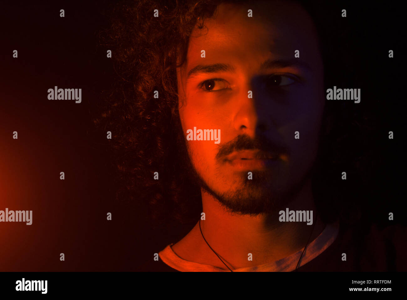 Portrait normalen lateinischen junger Mann expressive Suche auf der linken Seite mit rotem Licht. Gesichtsbehaarung: Schnurrbart, Bart Stockfoto